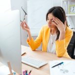 Головная боль напряжения у женщины во время работы за компьютером